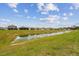 Spacious backyard view featuring a serene pond, perfect for enjoying nature and the outdoors at 11728 June Briar Loop, San Antonio, FL 33576
