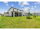 Expansive backyard with vibrant green lawn, complemented by an inviting screened patio, and tasteful landscaping at 11728 June Briar Loop, San Antonio, FL 33576