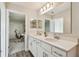 Bright bathroom featuring double sinks, white cabinetry, and a seamless view to a connected room at 11728 June Briar Loop, San Antonio, FL 33576
