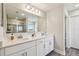 Bathroom with double sinks, quartz countertops, and a glass-enclosed shower at 11728 June Briar Loop, San Antonio, FL 33576
