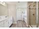 Bathroom featuring a double vanity, a glass-enclosed shower, and a separate soaking tub at 11728 June Briar Loop, San Antonio, FL 33576