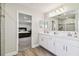 Bathroom with double sinks, quartz countertops, and a view to the primary bedroom at 11728 June Briar Loop, San Antonio, FL 33576