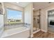 Bathroom with a view of the glass enclosed shower and soaking tub from the doorway at 11728 June Briar Loop, San Antonio, FL 33576