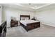Bedroom with neutral decor featuring dark wood furniture and soft gray carpet flooring at 11728 June Briar Loop, San Antonio, FL 33576