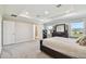 Bright bedroom with tray ceiling, featuring soft carpeting and windows overlooking the neighborhood at 11728 June Briar Loop, San Antonio, FL 33576