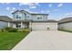 Charming two-story home featuring a three-car garage, covered porch, and beautifully landscaped front yard at 11728 June Briar Loop, San Antonio, FL 33576