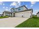 Attractive two-story home with a three-car garage, covered porch, and well manicured lawn at 11728 June Briar Loop, San Antonio, FL 33576