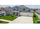Charming two-story home with a three-car garage, lush landscaping, and a welcoming front porch at 11728 June Briar Loop, San Antonio, FL 33576