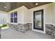 Inviting front porch with stone accents, decorative door, and a cozy, welcoming atmosphere at 11728 June Briar Loop, San Antonio, FL 33576