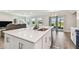 Modern kitchen featuring a large center island, stainless steel appliances, and a seamless view to the living area at 11728 June Briar Loop, San Antonio, FL 33576