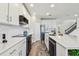 Bright kitchen with white cabinets, quartz countertops, stainless steel appliances, and a subway tile backsplash at 11728 June Briar Loop, San Antonio, FL 33576