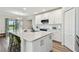 Modern kitchen with quartz countertops, white cabinetry, an island with seating, and stainless steel appliances at 11728 June Briar Loop, San Antonio, FL 33576