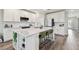 Bright kitchen with an island with seating, quartz countertops, white cabinetry, and stainless steel appliances at 11728 June Briar Loop, San Antonio, FL 33576