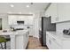 Bright kitchen with white cabinets, subway tile backsplash, stainless steel appliances, and wood floors at 11728 June Briar Loop, San Antonio, FL 33576