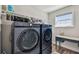 Modern laundry room featuring front loading washer and dryer with workspace at 11728 June Briar Loop, San Antonio, FL 33576