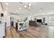 Open-concept living space with a modern island kitchen that flows into a comfortable living room with a sofa and media center at 11728 June Briar Loop, San Antonio, FL 33576
