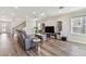 Comfortable living room with a gray reclining sofa and adjacent staircase and modern media center at 11728 June Briar Loop, San Antonio, FL 33576