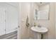 Stylish powder room featuring a modern pedestal sink, ample lighting, and elegant decor at 11728 June Briar Loop, San Antonio, FL 33576