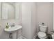 Modern powder room with a sleek pedestal sink, contemporary fixtures, and neutral color scheme at 11728 June Briar Loop, San Antonio, FL 33576
