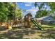 Wooden playset and swing set in a spacious backyard, perfect for Gathering fun and outdoor activities at 17904 Singing Wood Pl, Lutz, FL 33548