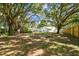 Oversized backyard featuring mature trees and a partially screened-in patio, perfect for outdoor living at 17904 Singing Wood Pl, Lutz, FL 33548