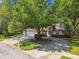 Charming single-story home featuring a circular driveway, attached garage, and lush landscaping at 17904 Singing Wood Pl, Lutz, FL 33548