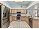 Modern kitchen featuring stainless steel appliances, granite countertops, and ample cabinet space at 17904 Singing Wood Pl, Lutz, FL 33548