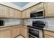 Well-lit kitchen featuring wooden cabinets, granite countertops, and modern stainless steel appliances at 17904 Singing Wood Pl, Lutz, FL 33548