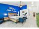 Naturally lit bedroom with an exercise machine, backyard access, and a blue accent wall at 17904 Singing Wood Pl, Lutz, FL 33548
