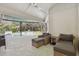 Covered outdoor patio with wicker chairs overlooking the screened-in pool area at 17904 Singing Wood Pl, Lutz, FL 33548