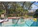 Screened-in pool with attached spa and spacious backyard with playground, perfect for outdoor entertaining and Gathering fun at 17904 Singing Wood Pl, Lutz, FL 33548