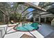 Beautiful backyard pool area with screened-in enclosure and mature trees at 17904 Singing Wood Pl, Lutz, FL 33548