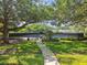 Image of community tennis court surrounded by a green lawn, mature trees, and lush landscaping at 17904 Singing Wood Pl, Lutz, FL 33548