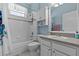 Charming bathroom with tiled walls, a combination tub and shower, and white cabinets at 14820 Potterton Cir, Hudson, FL 34667