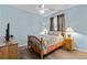 Cozy bedroom with wood floors, ceiling fan, side table, and ample natural light at 14820 Potterton Cir, Hudson, FL 34667