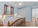 Well-lit bedroom features hard wood flooring, a ceiling fan, and double door closet at 14820 Potterton Cir, Hudson, FL 34667