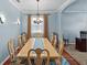 Dining room with large wooden table and decorative lighting fixture at 14820 Potterton Cir, Hudson, FL 34667