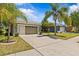 Charming home with a well-manicured lawn, a two-car garage, and a sunny sky at 14820 Potterton Cir, Hudson, FL 34667