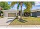 Charming single-story home featuring a well-manicured lawn and an attached two-car garage at 14820 Potterton Cir, Hudson, FL 34667