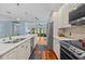 Modern kitchen featuring stainless steel appliances, white cabinetry, and an eat-in island at 14820 Potterton Cir, Hudson, FL 34667