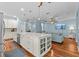 Open kitchen layout with a large island, white cabinets, and hardwood floors overlooking the living area at 14820 Potterton Cir, Hudson, FL 34667