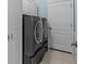 Convenient laundry room with gray washer and dryer units and tiled floor at 14820 Potterton Cir, Hudson, FL 34667