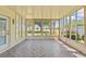Bright sunroom with tile flooring and walls of windows overlooking the landscaped yard at 14820 Potterton Cir, Hudson, FL 34667