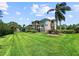 Expansive backyard with lush, green grass and a view of the home's facade at 7020 Hawks Harbor Cir, Bradenton, FL 34207