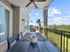 Outdoor dining area on the balcony with views of lush greenery and blue skies at 7020 Hawks Harbor Cir, Bradenton, FL 34207