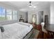 Bright bedroom with large windows, ceiling fan, hardwood floors, and a full-length mirror at 7020 Hawks Harbor Cir, Bradenton, FL 34207