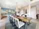 Open-concept dining room with a large wood table, designer chandelier, and views of the kitchen at 7020 Hawks Harbor Cir, Bradenton, FL 34207