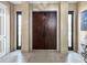 Spacious entryway with a decorative wood double door, sidelights, and tile flooring at 7020 Hawks Harbor Cir, Bradenton, FL 34207