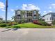 Stunning three-story home featuring manicured landscaping, dual balconies, and a grand entrance at 7020 Hawks Harbor Cir, Bradenton, FL 34207