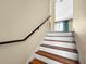 Stairway featuring wood and white steps and a black handrail at 7020 Hawks Harbor Cir, Bradenton, FL 34207